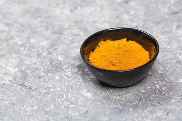 Turmeric powder close up on a grunge cooking table