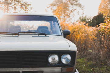 Old soviet car in sunset, detailed front view. Retro aesthetics concept, old vehicle among...