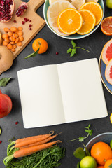 food, healthy eating and diet concept - close up of notebook, fruits and vegetables on slate table top