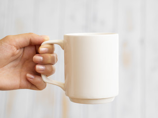 Close-up hand holding up a mug