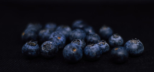 Some fresh and healthy blueberries on black background