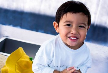 An asian boy is smiling and standing outside