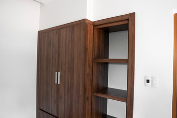 Modern brown wooden wardrobe in the room.