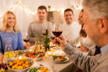 celebration, holidays and people concept - happy family having dinner party, drinking red wine and toasting at home