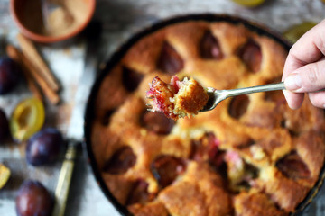 Selective focus. Slice of plum pie on a fork. Homemade American plum pie. Macro.