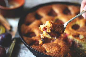 Selective focus. Slice of plum pie on a fork. Homemade American plum pie. Macro.