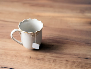 Tea bag in white ceramic cup.