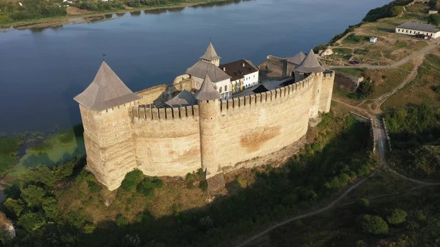 Aerial view of old castle near the River. Hotyn Castle in Ukraine. Eastern Europe. Tracking from right to left.