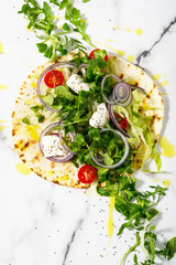 Unwrapped tortilla with fresh salad and roasted chicken and a bowl of sauce. Top view shot. Gourmet conception.