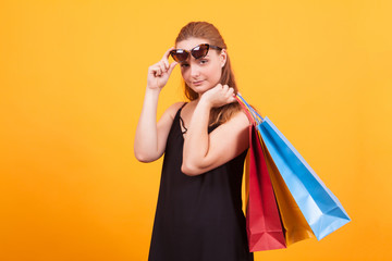 Beautiful girl wearing sunglasses and holding shopping bags