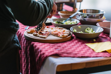 Buffet table with pizza on wooden tray