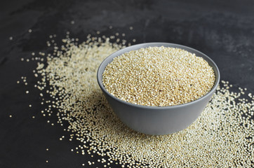 Quinoa in bowl over dark background, healthy food concept