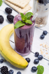 Banana, blueberry, blackberry, oatmeal and yogurt smoothies in a glass