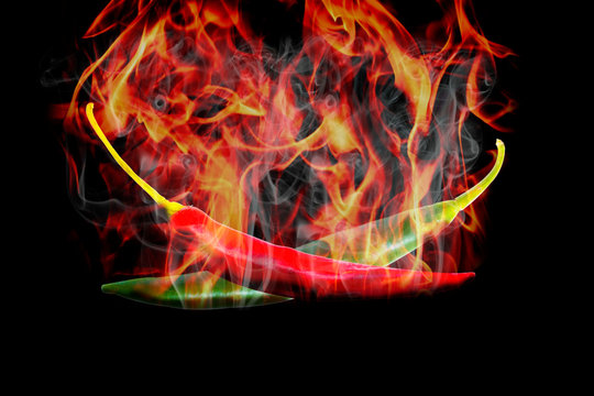 Chili burned to high heat. Two pieces, green and red, black background