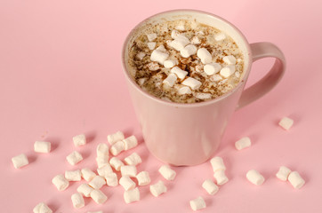 Cup of coffee with marshmallows on a pink background