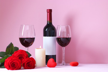 red wine and roses on the table. Valentine's day background. A gala dinner for two.