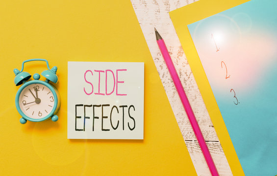Conceptual hand writing showing Side Effects. Concept meaning secondary undesirable effect of a drug or medical treatment Notepads marker colored paper sheets alarm clock wooden background