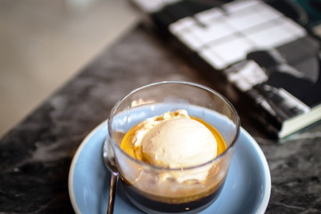Affogato coffee: espresso shot with salted caramel icecream on classic marble table background.