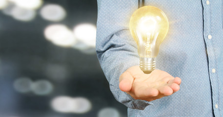 Hand of holding illuminated light bulb, innovation inspiration concept