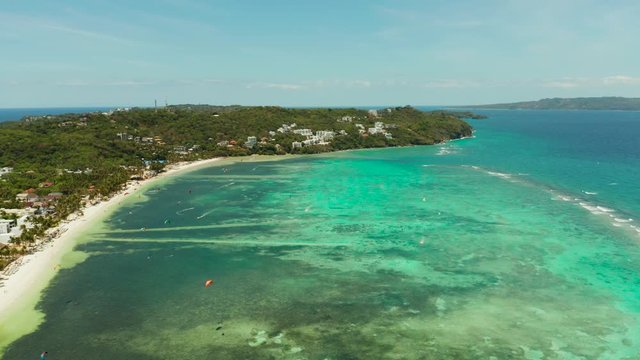 Tropical beach with turquoise water with kite-surfer rides, aerial view. Kitesurfing on a tropical island. Boracay, Philippines
