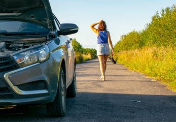 Beautiful young girl, in despair, she can not continue her journey because of the fact that her car broke down.