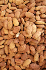 Almonds. Overhead view of raw organic almonds as a background. Peeled almond nuts. Healthy food concept. Vegetarian. Nuts pattern