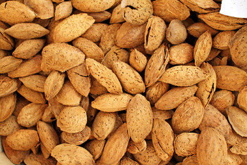 Almonds. Raw organic almonds as a background. Almond nuts with shells. Healthy food concept. Vegetarian. Nuts pattern