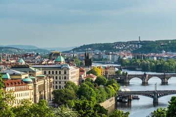 Obraz premium Aerial view of citycape of old town of Prague, with a lot of rooftops, churches, and the landmark of Charles Bridge, and Vltava river.