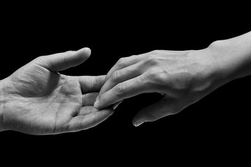 Black and white photo of two hands at the moment of breakup. The concept of  breakup. On black...