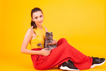 Obraz premium Beautiful girl smiling while holding her adorable cat