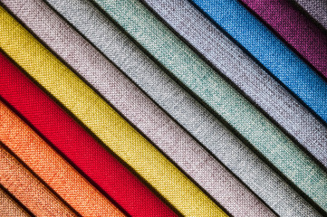 Colorful and bright fabric samples of furniture and clothing upholstery. Close-up of a palette of...