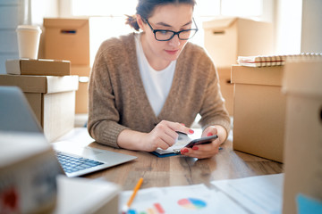 Woman is working at warehouse for online store.
