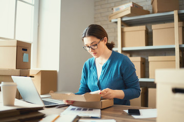 Woman is working at warehouse for online store.