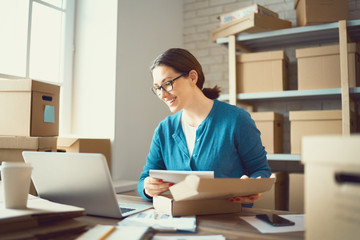Woman is working at warehouse for online store.