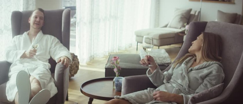 a couple sitting in armchairs in the lounge of a spa having conversation and drinking wine - Ein Paar sitzt in Sesseln der Lounge eines Spas, unterhalten sich und trinken Wein 4K ProRes Footage