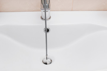 Cleaning clogged sink pipe in bathroom