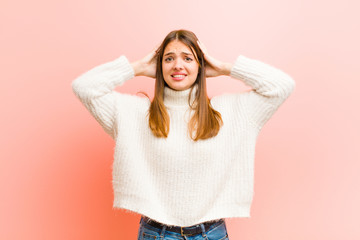 young pretty woman feeling stressed, worried, anxious or scared, with hands on head, panicking at...