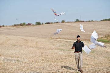 South asian agronomist farmer threw the papers into the sky at wheat field. Agriculture production concept.