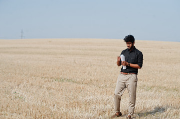 Naklejka na ściany i meble South asian agronomist farmer inspecting wheat field farm. Agriculture production concept.