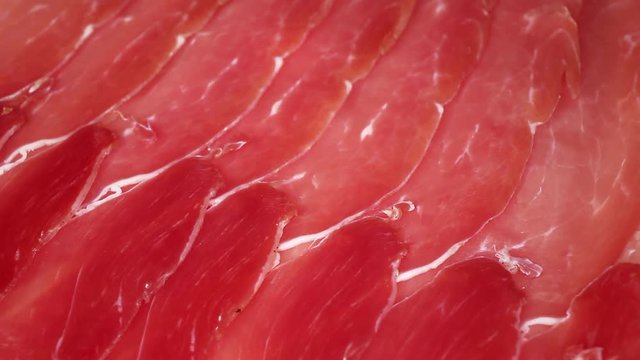 Prosciutto crudo cured ham footage video on slow motion rotating rolling plate