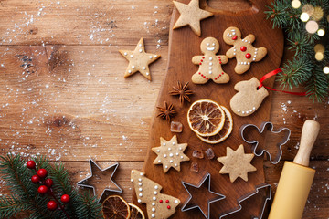 Christmas gingerbread cookies and fir tree on kitchen board top view. Homemade sweet pastries for...