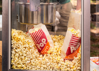 Popcorn inside a popcorn machine at an outdoor festival - obrazy, fototapety, plakaty
