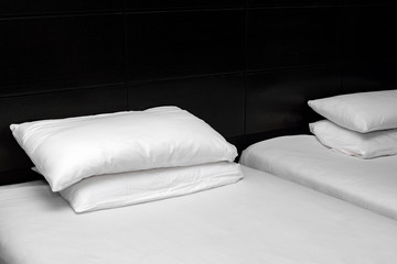 Fototapeta na wymiar White sheets and pillow at the head of the black bed