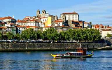 Tourist boat on Douro river overlooking Porto, Portugal