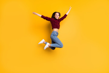 Full length photo of lovely girl smiling raising her arms smiling wearing marsala pullover isolated over yellow background