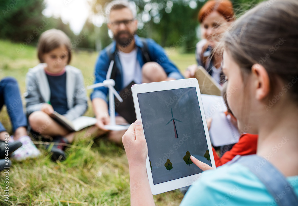 Sticker group of school children with teacher and windmill model on field trip in nature.