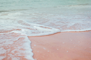 Soft green mint waves of the sea with white foam on the sandy beach. © Ira_Shpiller