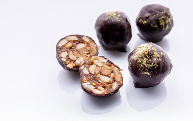 Handmade chocolates with peanuts and honey. Gourmet chocolates on a white background. Close-up. Soft focus