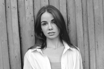Fototapeta premium Portrait of beautiful young woman on the wooden background. Black and white.
