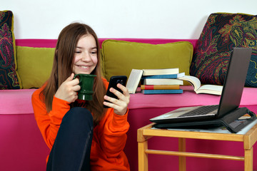 happy teenage girl with smartphone and laptop at home